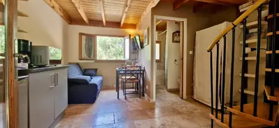 a living room with a blue couch and a kitchen at Escapades en Ventoux in Venasque