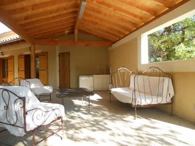 a patio with chairs and a table and a window at Escapades en Ventoux in Venasque