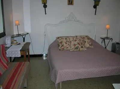 a bedroom with a bed and a table with two lamps at Le Mas des Baux in Bédoin