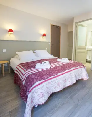 a bedroom with a large bed with two towels on it at La Garance in Bédoin