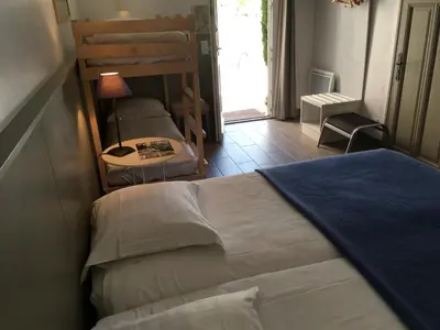a bedroom with a bed and a table with a lamp at La Garance in Bédoin