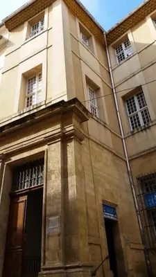 a tall building with windows and a door on it at Duplex 6 personnes, ascenseur, zone pietonne, 1 bis Rue Aude in Aix-en-Provence