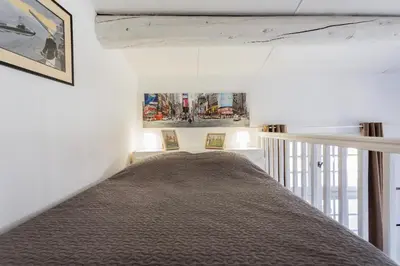 a bed in a room with white walls at Duplex 6 personnes, ascenseur, zone pietonne, 1 bis Rue Aude in Aix-en-Provence