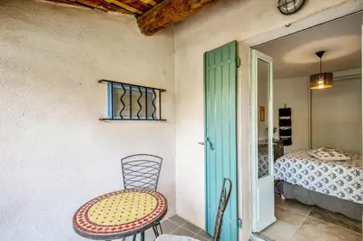 a table and chair in a room with a bed at Charmante Maison à Bonnieux avec Terrasse et Vue sur le Jardin in Bonnieux