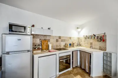 a kitchen with a refrigerator and a microwave at Charmante Maison à Bonnieux avec Terrasse et Vue sur le Jardin in Bonnieux