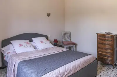 a bedroom with a bed and a dresser and a chair at Villa Enzo in Orgon