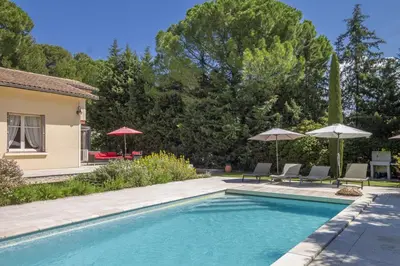 a swimming pool with two chairs and umbrellas at Villa Enzo in Orgon