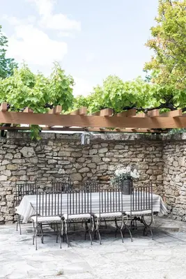 a table and benches in front of a stone wall at Domaine de Saint Pons in Villars