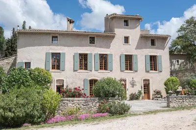 a large stone house with green shutters at Domaine de Saint Pons in Villars