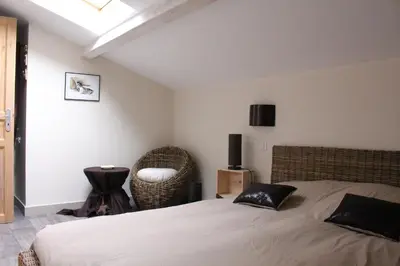 a bedroom with a bed and a chair at Bastide de Fanny in Rognes