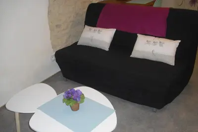 a black couch with two tables and a plant on it at Lou mas li Pitchoun 