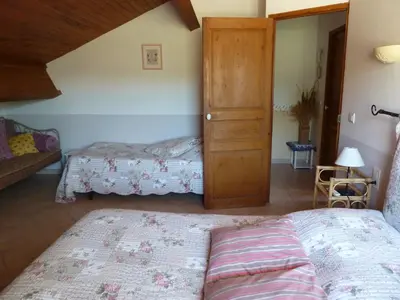a bedroom with two beds and a wooden door at Les Cigales in Saint-Andiol