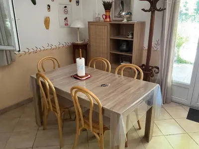 a dining room table with chairs and a candle on it at Les Cigales in Saint-Andiol