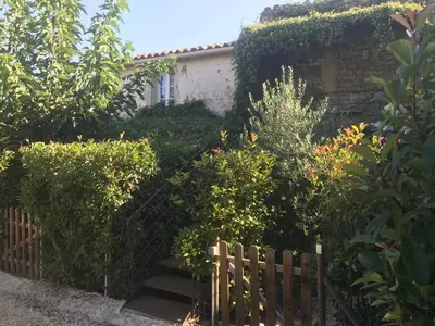 a fence in front of a house with bushes at Lou mas li Pitchoun 