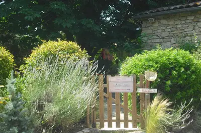 a garden with a sign and some bushes at Lou mas li Pitchoun 