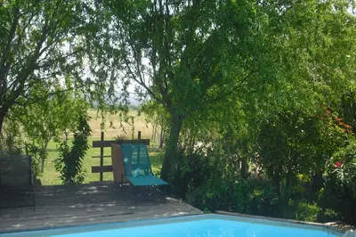 a blue chair sitting on a deck next to a tree at Lou mas li Pitchoun 