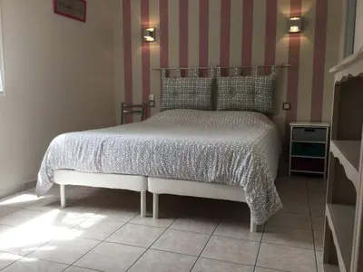 a bedroom with a bed and a striped wall at Beautiful provencal vacation rental in L'Isle sur la Sorgue in LʼIsle-sur-la-Sorgue