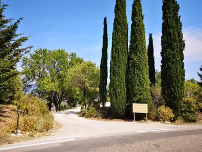 a road with trees and a sign in the middle at La Bastide du Limon in Mormoiron