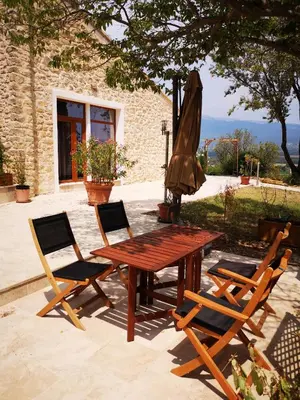 a wooden table with two chairs and an umbrella at La Bastide du Limon in Mormoiron