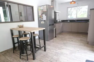 a kitchen with a table and a refrigerator at A pretty family house located in a tranquil area with a pretty view of the Luberon range. in Les Taillades