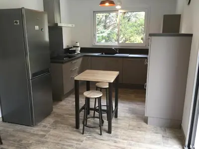 a kitchen with a wooden table and a refrigerator at A pretty family house located in a tranquil area with a pretty view of the Luberon range. in Les Taillades