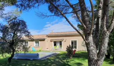 a villa with a pool in front of a house at A pretty family house located in a tranquil area with a pretty view of the Luberon range. in Les Taillades