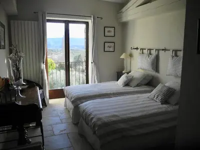 a bedroom with two beds and a large window at OUSTAU DE PIERA in Gordes