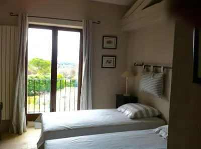 a bedroom with a bed and a large window at OUSTAU DE PIERA in Gordes