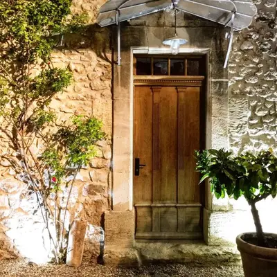 a wooden door on the side of a stone building at superb prestigious mas with pool in the countryside of caumont sur durance, close to avignon, sleeps 8 in Caumont-sur-Durance