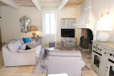 a living room with white furniture and a fireplace at superb prestigious mas with pool in the countryside of caumont sur durance, close to avignon, sleeps 8 in Caumont-sur-Durance