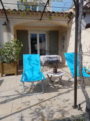 two blue chairs and a table on a patio at fleur de garance in Le Thor