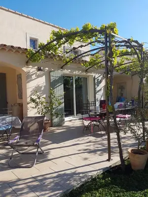 a patio with chairs and a table and a tree at fleur de garance in Le Thor