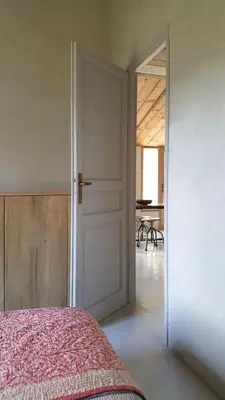 a bedroom with a bed and a door with a table at La petite maison in Aix-en-Provence