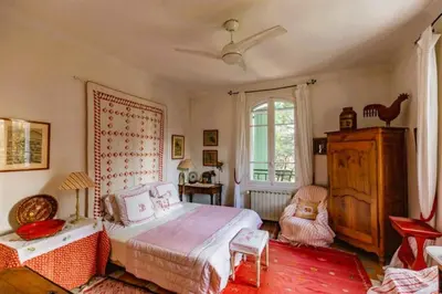 a bedroom with a bed and a chair and a window at Le Domaine de Saint Veran in Orgon