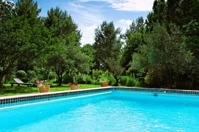 a swimming pool in a yard with trees at Le Domaine de Saint Veran in Orgon