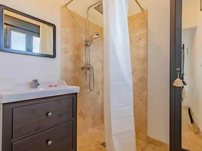 a bathroom with a shower with a sink and a mirror at Holiday Home L'Oliveraie by Interhome in Saint-Didier