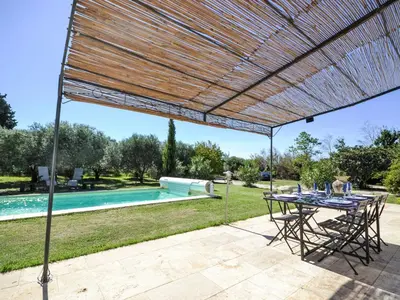 a patio with a table and chairs and a pool at Holiday Home L'Oliveraie by Interhome in Saint-Didier