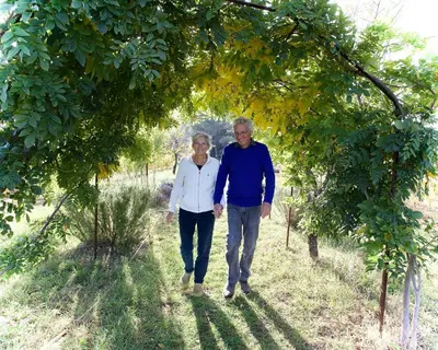 a man and woman walking through a tree tunnel at LA RESPELIDANE in Caromb