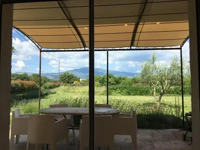 a table and chairs with a view of a field at LA RESPELIDANE in Caromb