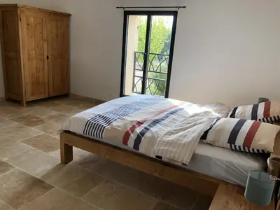 a bed in a room with a window at Mas Eléhis Gîtes en Provence in Pernes-les-Fontaines