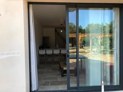 an open glass door to a patio with a table at Mas Eléhis Gîtes en Provence in Pernes-les-Fontaines