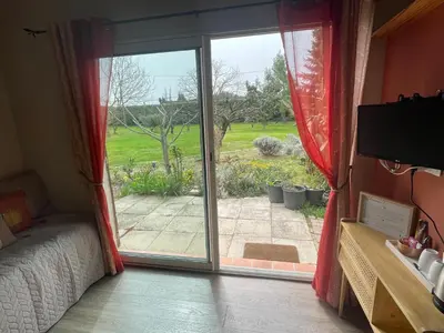 a bedroom with a sliding glass door to a garden at La Gourmandine in Saint-Andiol