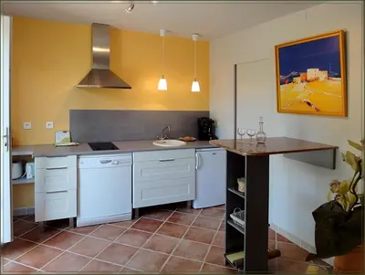 a kitchen with white appliances and a table in it at Gite La Gourmandine in Saint-Andiol