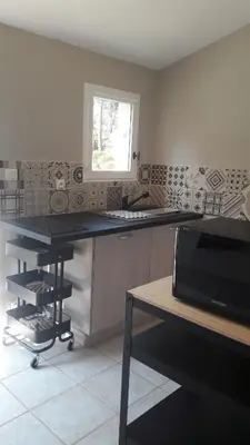 a kitchen with a counter and a sink and a window at Les Oursillons in Roussillon