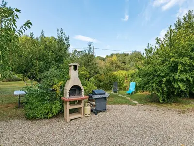 a outdoor grill with a stove in a yard at Modern holiday home with private pool in Lambesc