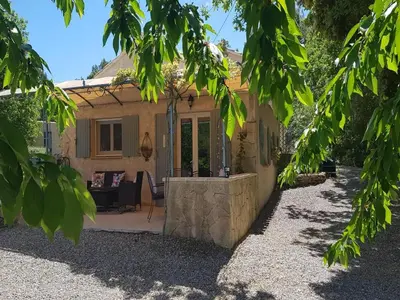 a stone house with a patio and a table at Modern holiday home with private pool in Lambesc