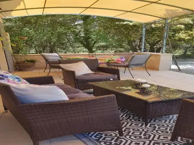 an outdoor patio with chairs and tables and an umbrella at Modern holiday home with private pool in Lambesc