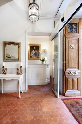 a hallway with a door and a table and a mirror at Les Quatre Dauphins in Aix-en-Provence