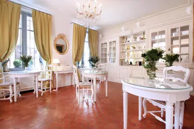 a dining room with white tables and chairs and a chandelier at Les Quatre Dauphins in Aix-en-Provence