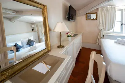 a mirror in a room with a bed and a desk at Les Quatre Dauphins in Aix-en-Provence